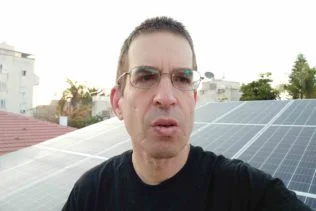 אדם על רקע פאנלים סולאריים